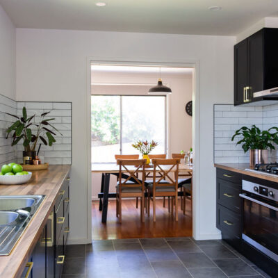 black kitchen cabinetry with timber laminate benchtops